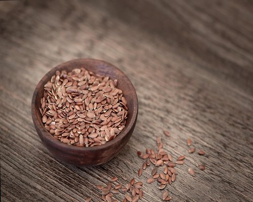 A bowl filled with mixed whole grains including brown rice, quinoa, and oats, topped with seeds.